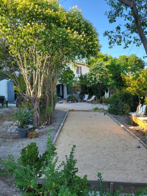 einen Garten mit Bäumen und einem Feldhof in der Unterkunft Studette indépendante et coquette avec terrasse sur jardin in Marseille
