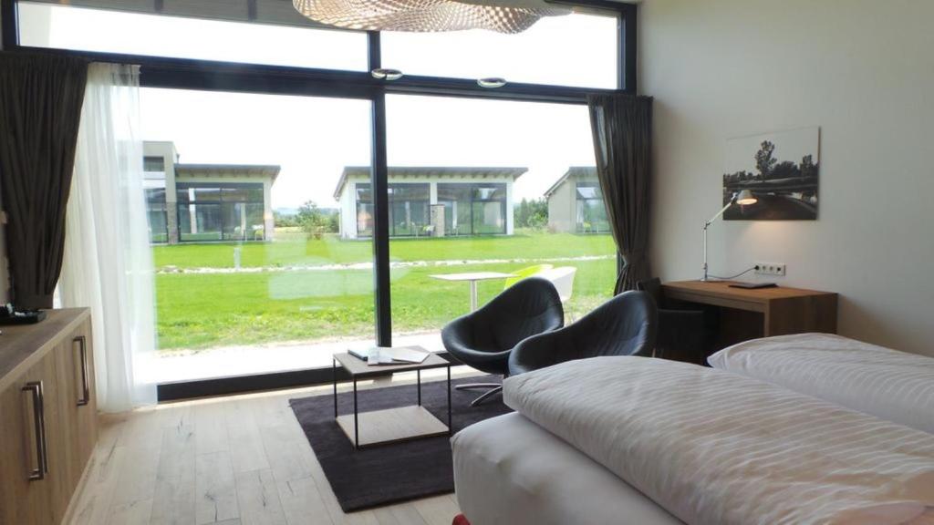 a bedroom with two beds and a large window at Hotel Diamond Country Club in Atzenbrugg