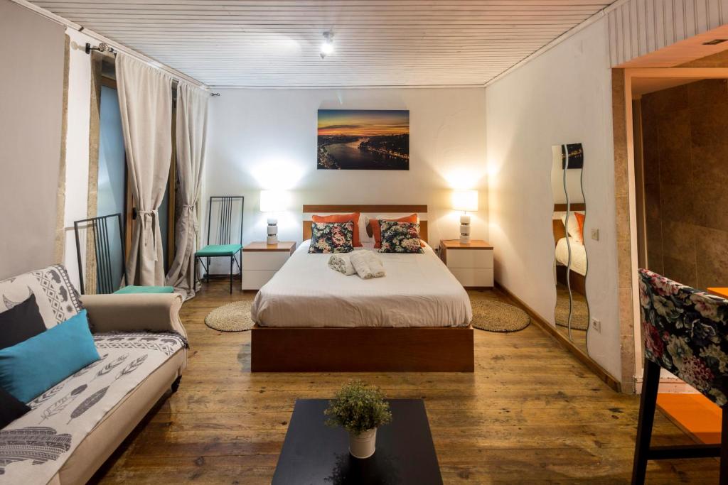 Habitación de hotel con cama y sofá en Guest H4U - Porto River View en Oporto