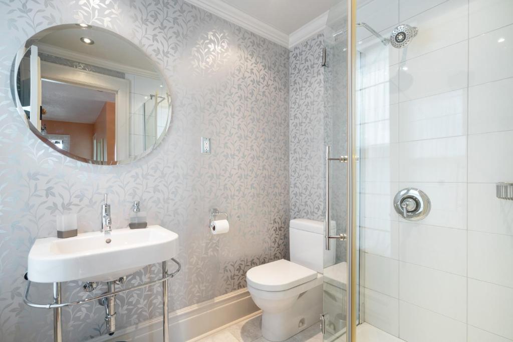 a bathroom with a toilet and a sink and a mirror at Lion's Head B&B in Niagara Falls