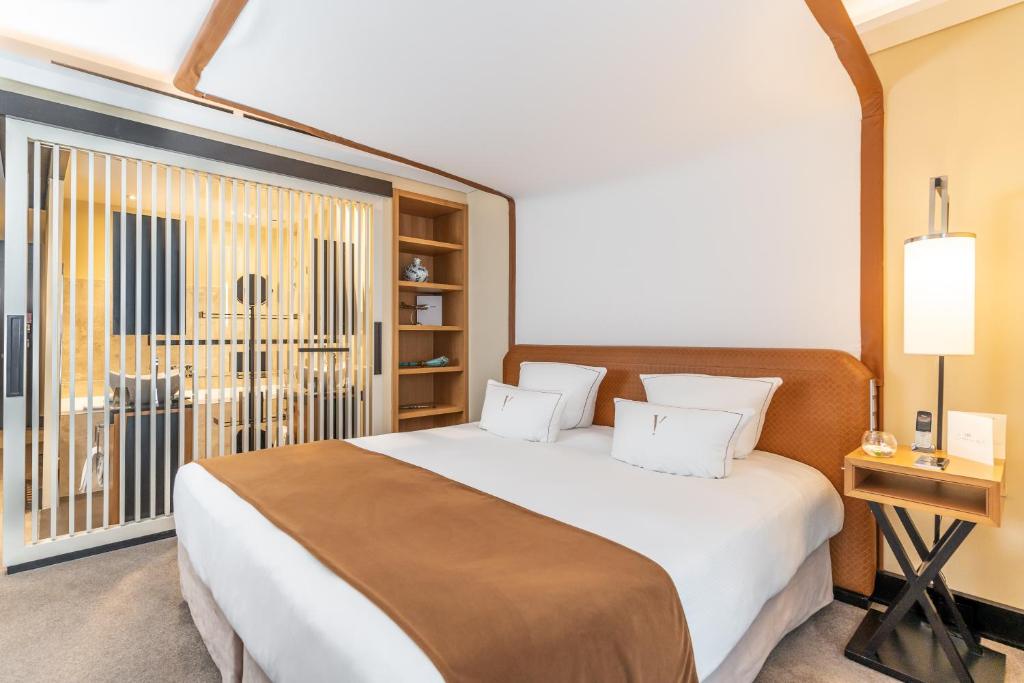 a bedroom with a large bed and a large window at Five Seas by Inwood Hotels in Cannes