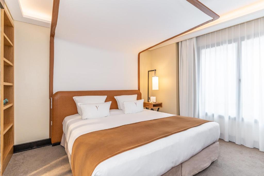 a bedroom with a large bed and a large window at Five Seas by Inwood Hotels in Cannes