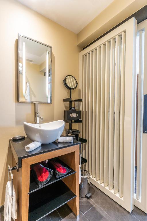 a bathroom with a sink and a mirror at Five Seas by Inwood Hotels in Cannes