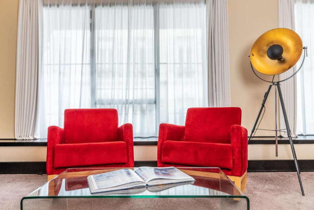 two red chairs and a glass table in a living room at Five Seas by Inwood Hotels in Cannes