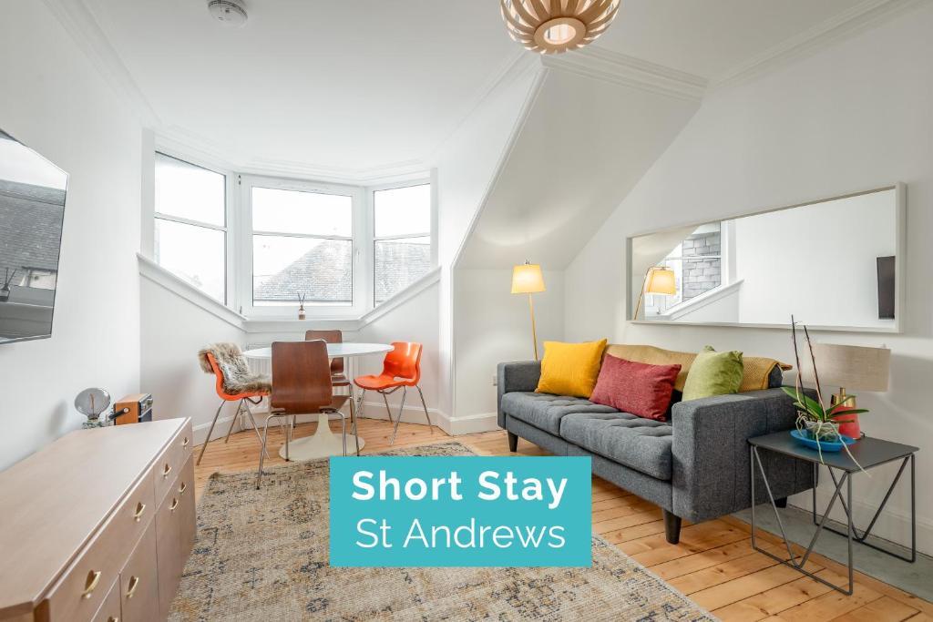 a living room with a couch and a table at Chic Central 2 Bed Loft Apartment in St. Andrews