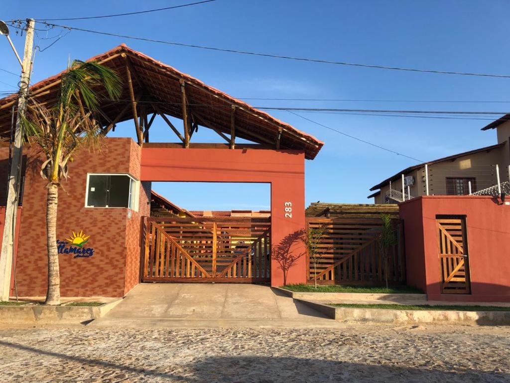 ceglany budynek z dużą drewnianą bramą w obiekcie Apartamento em Luís Correia w mieście Luis Correia