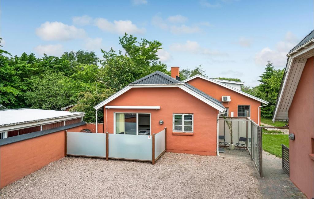 a orange house with a fence in front of it at 1 Bedroom Amazing Apartment In Hjrring in Hjørring