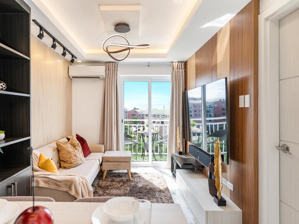 537 AMANI LUXURY SUITE, 4 Minutes to Airport, FAST WIFI, Free Netflix في Pusok: غرفة معيشة مع أريكة وتلفزيون