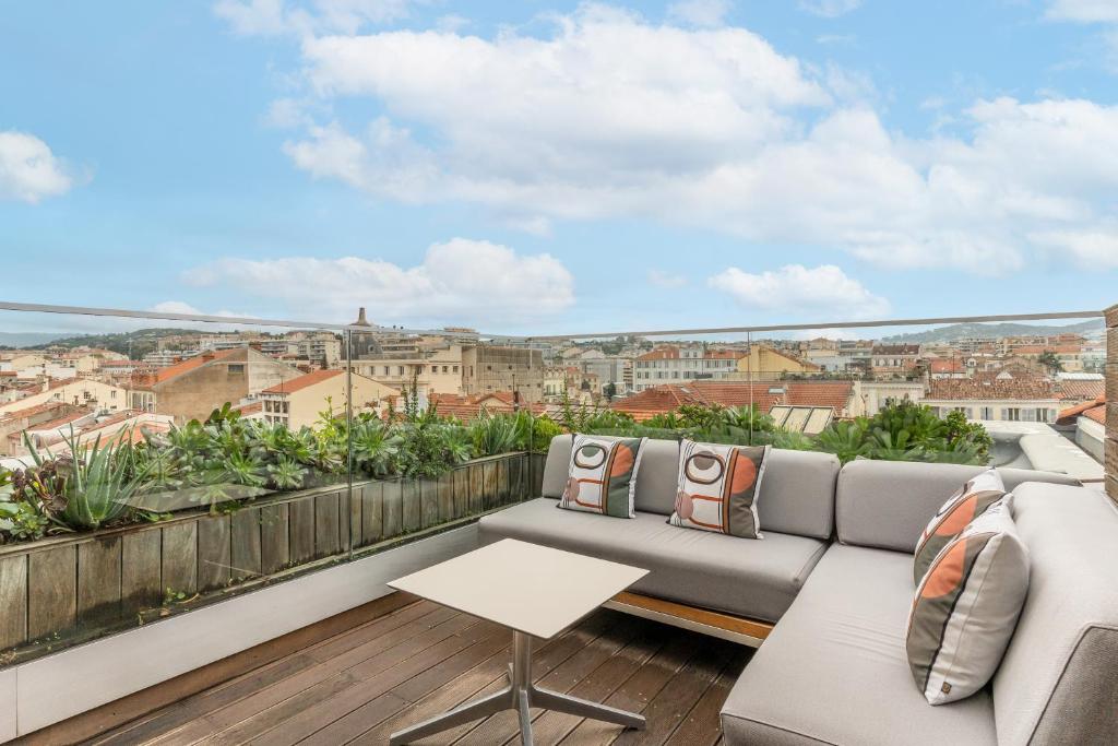 a balcony with a couch and a view of the city at Five Seas by Inwood Hotels in Cannes