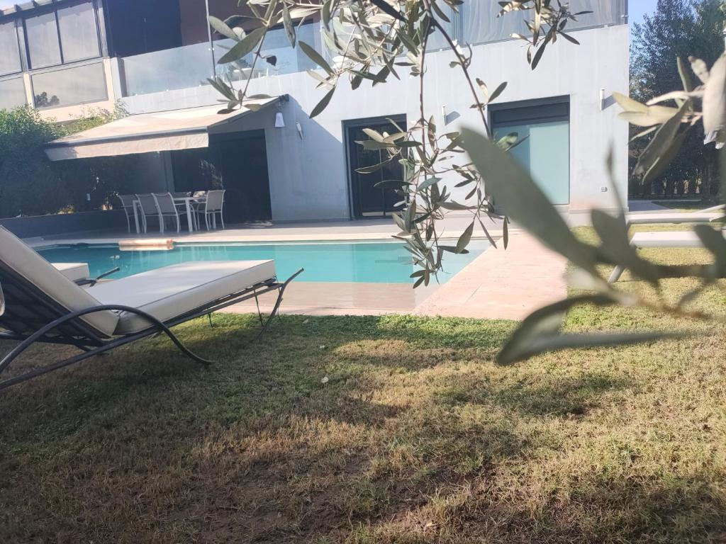 a pool with a chair next to a building at Villa Sara avec sa piscine et jardin in Marrakesh