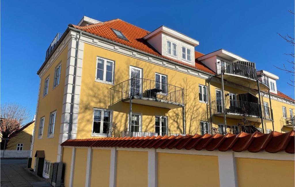un edificio amarillo con balcones en un lateral en Gorgeous Apartment In Skagen With Kitchen, en Skagen