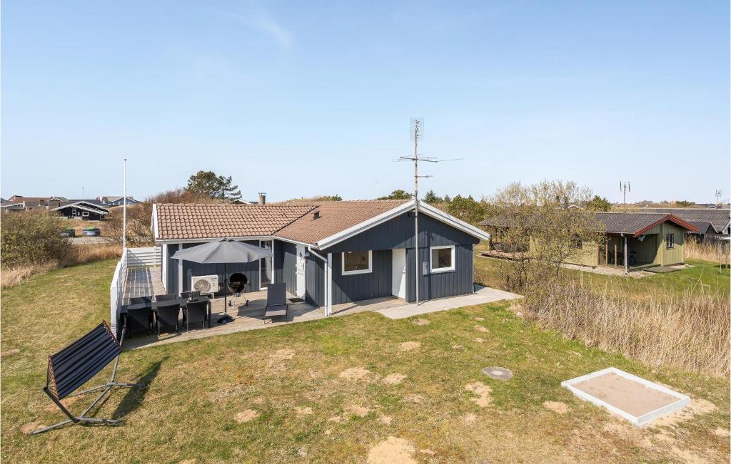 an aerial view of a blue house with a yard at Nice Home In Rm With 3 Bedrooms, Sauna And Wifi in Lakolk