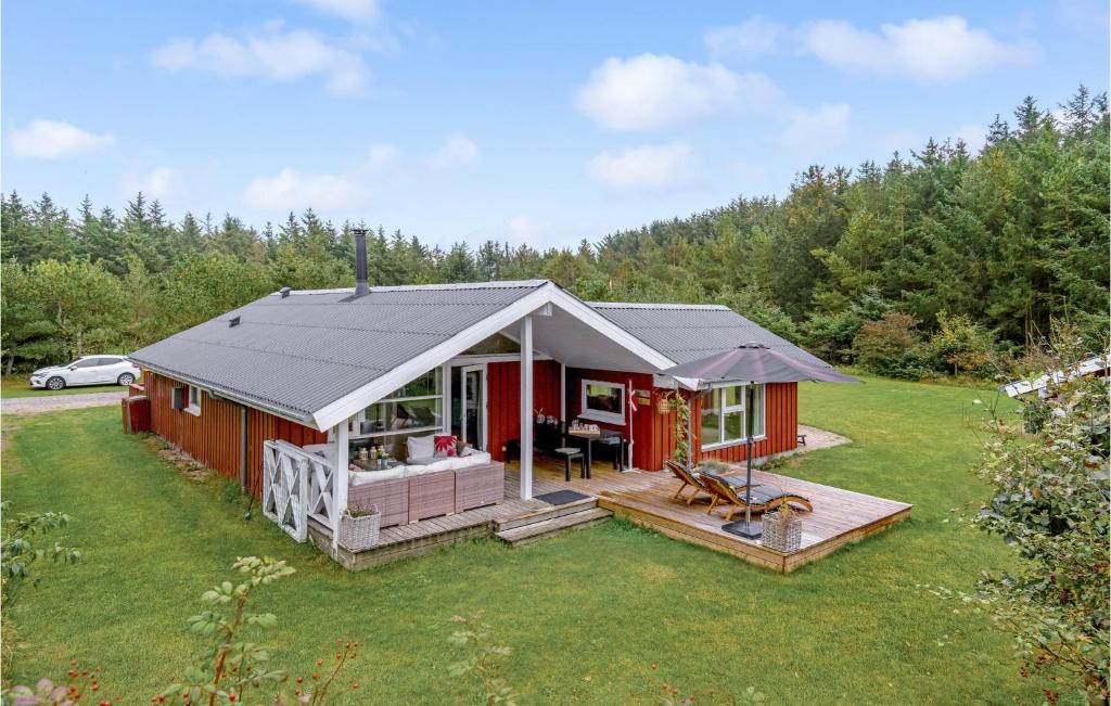 une cabine rouge avec une terrasse couverte et une cour dans l'établissement Nice Home In Lkken With Indoor Swimming Pool, à Trudslev