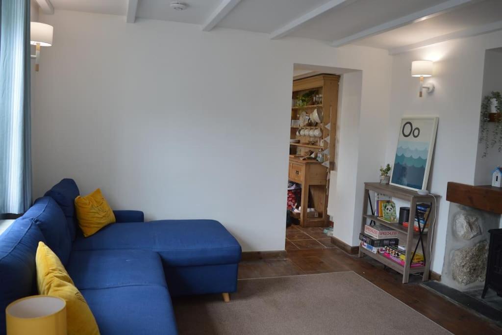 un soggiorno con divano blu in una camera di 2-bedroom cottage in heart of St Ives w/ parking a St Ives