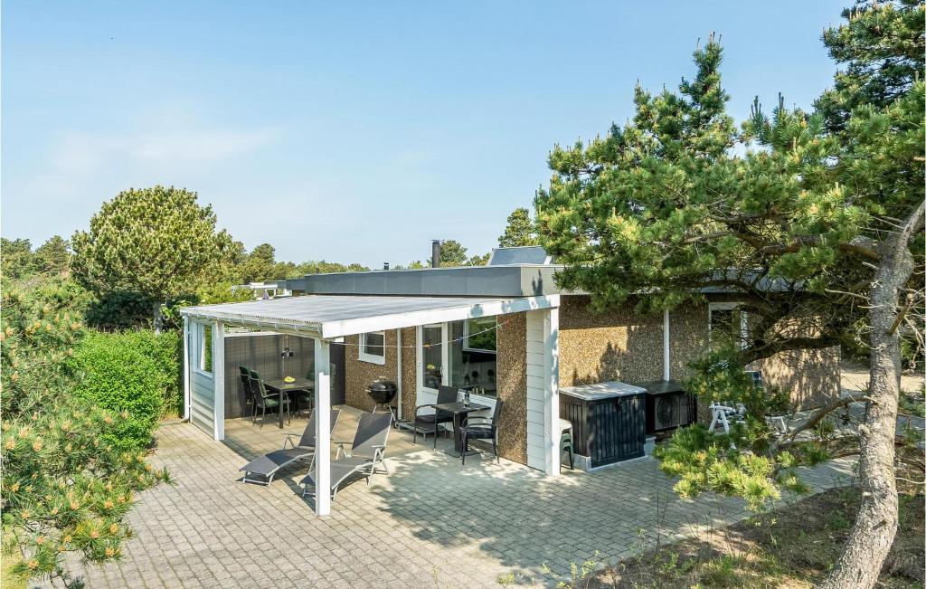 a glass house with a patio and a grill at Stunning Home In Blvand With 3 Bedrooms And Wifi in Blåvand