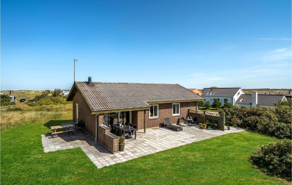 a brick house with a patio in a yard at Holiday Home Clemmessti in Klitmøller