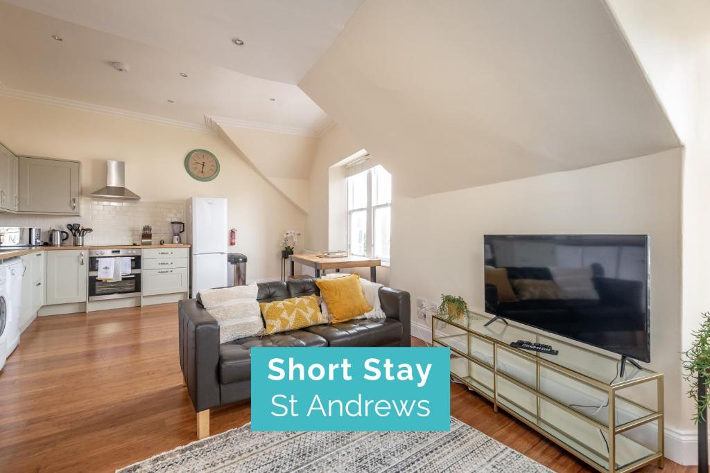 uma sala de estar com um sofá e uma televisão de ecrã plano em Skye Sands - Central Apartment near The Old Course em St. Andrews