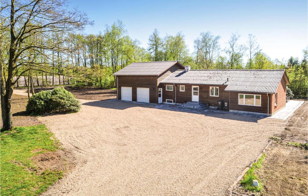 a house with a dirt driveway in front of it at Five-Bedroom Holiday Home In Kibak in Ørbæk