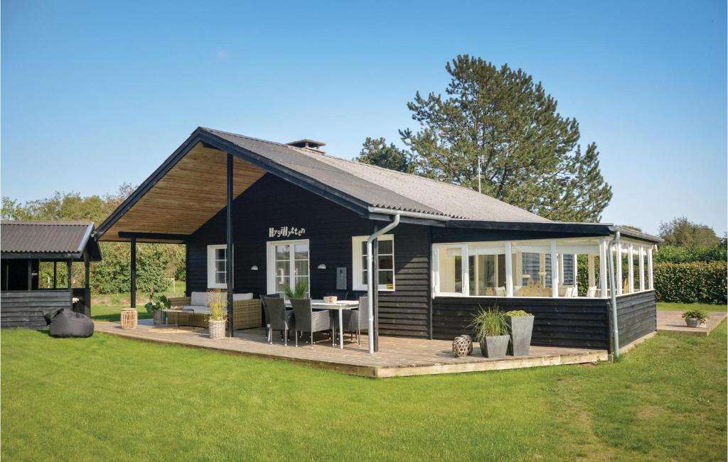 a black cottage with a patio and a table at Hygihytten in Hemmet