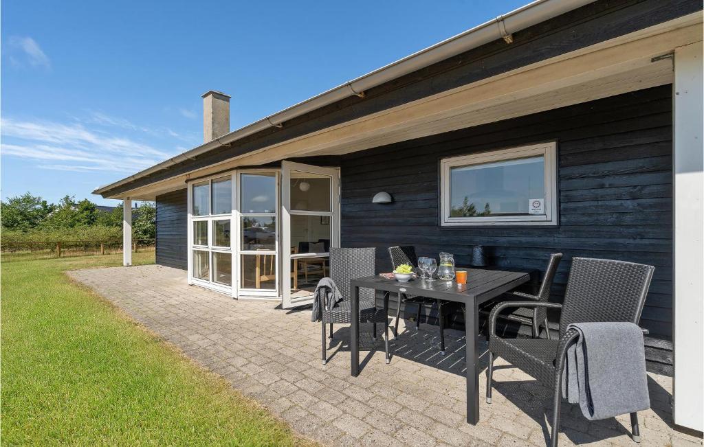 Un patio con una mesa y sillas frente a una casa. en Holiday Home Tranebærvej Denm, en Hemmet