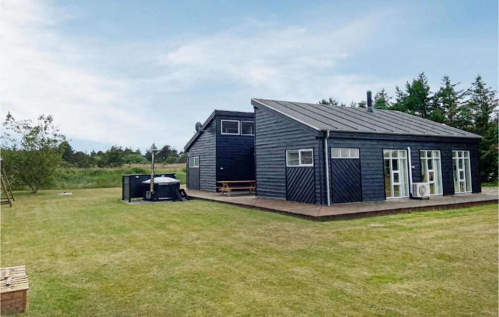 a black tiny house on a deck in a yard at Nice Home In Hurup Thy With House A Panoramic View in Sindrup