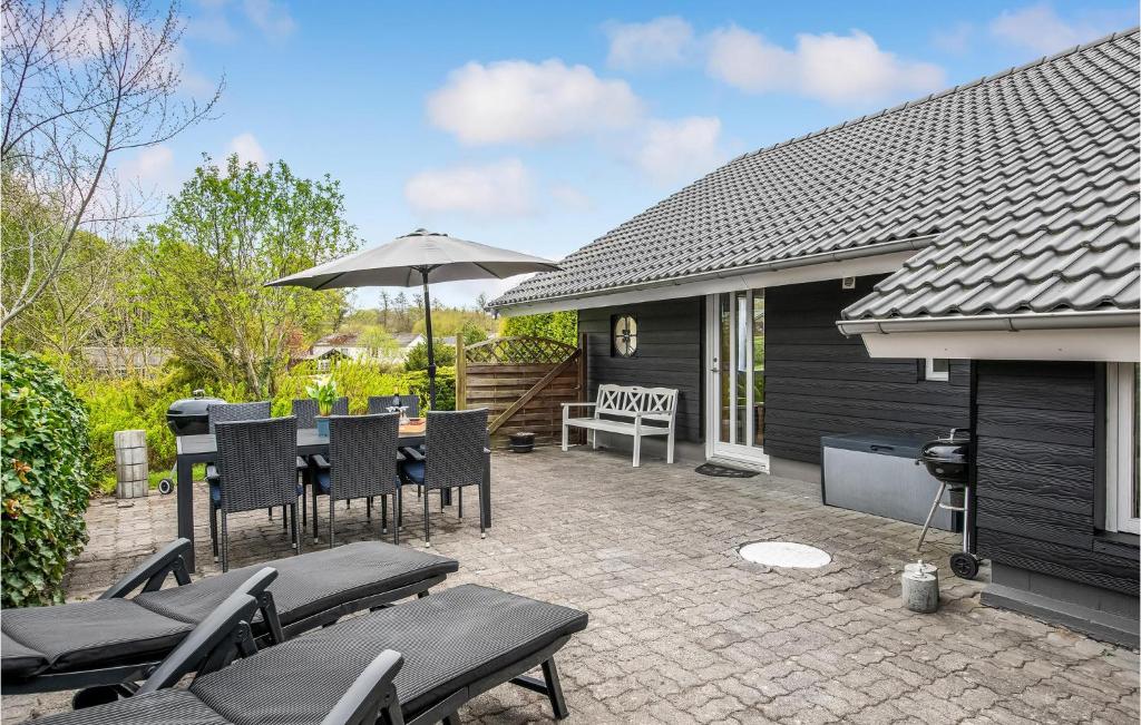 a patio with chairs and a table and an umbrella at 3 Bedroom Lovely Home In Aabenraa in Aabenraa