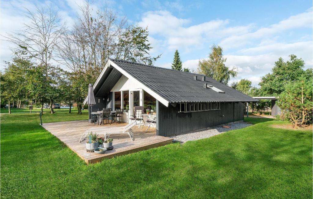 a black and white house with a wooden deck at Amazing Home In Lgstr With Kitchen in Trend