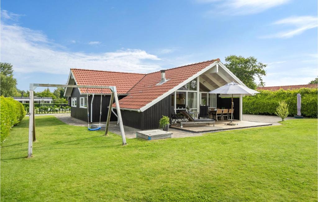 Amazing Home In Broager With 3 Bedrooms, Sauna And Wifi في Broager: منزل أسود صغير مع ساحة عشب