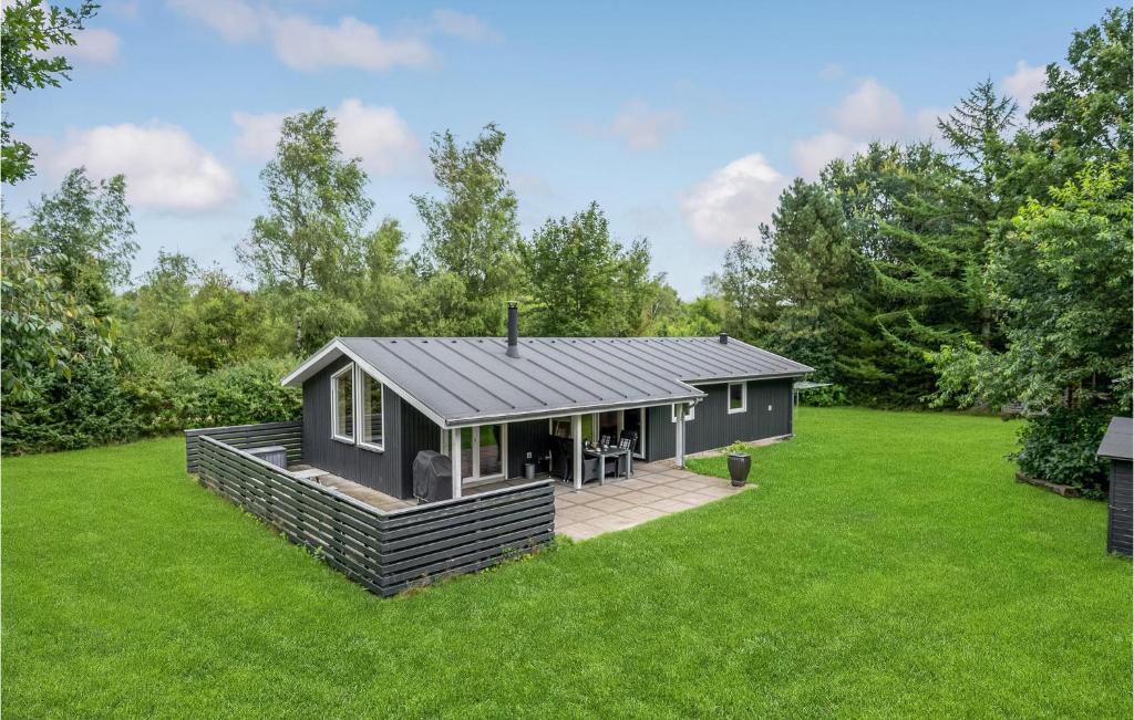 3 Bedroom Cozy Home In Herning في هيرنينغ: منزل أسود صغير على عشب أخضر