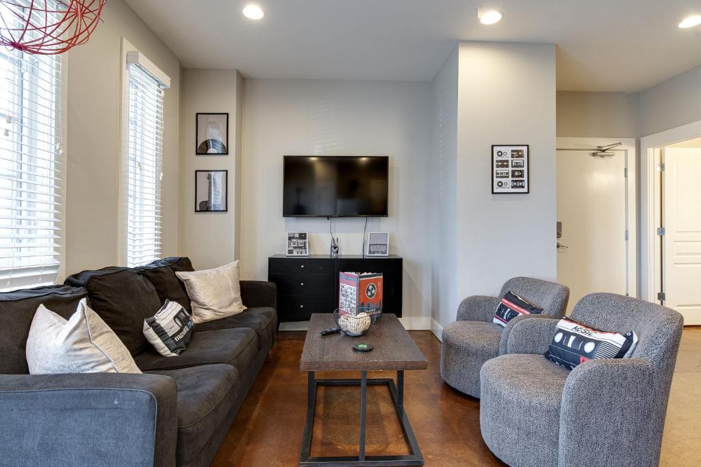 a living room with a couch and two chairs and a tv at Music Row Nashville King Beds Keyless Entry in Nashville