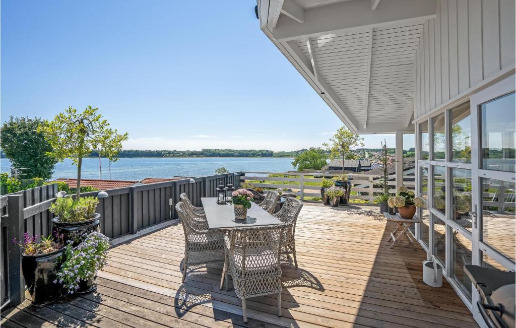 a deck with a table and chairs on a house at Søglimt in Hejls