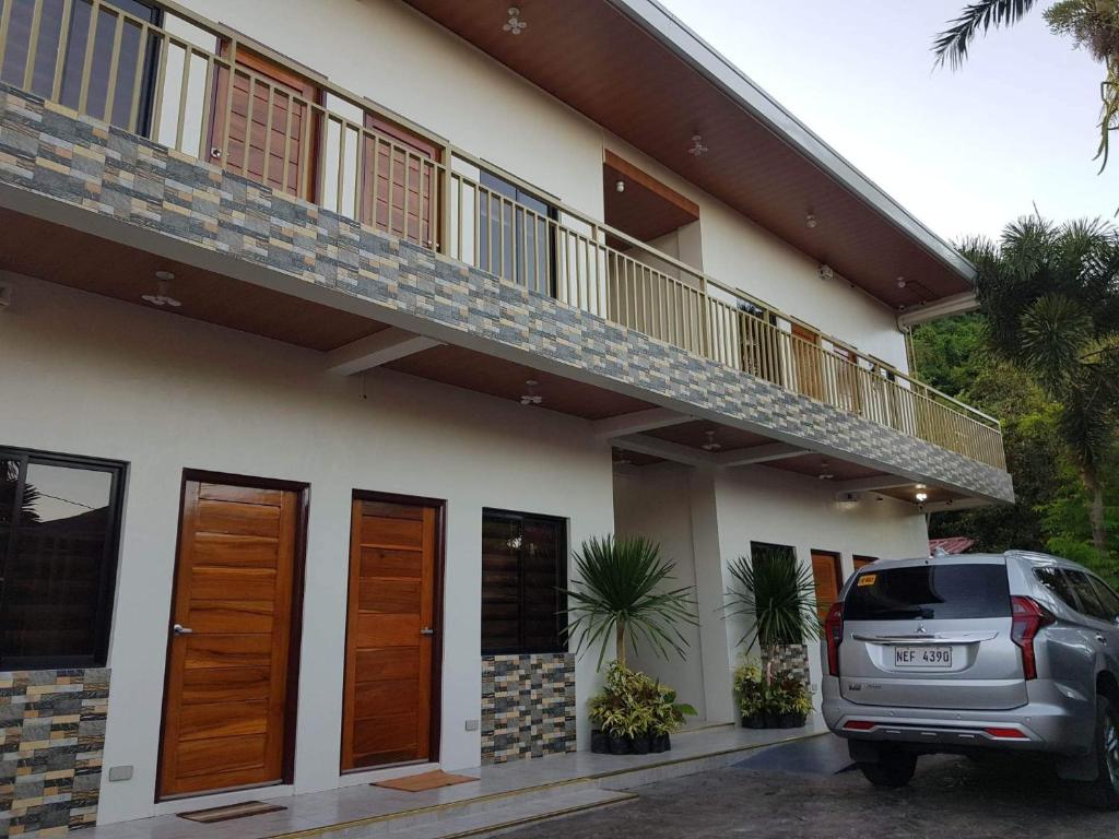 un coche aparcado delante de una casa en FLB Apartelle Los Banos, en Los Baños