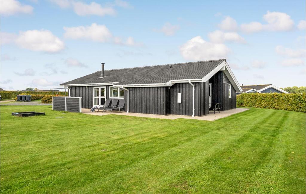 ÅrøsundにあるAmazing Home In Haderslev With 4 Bedrooms, Sauna And Wifiの広い緑の庭のある黒い家