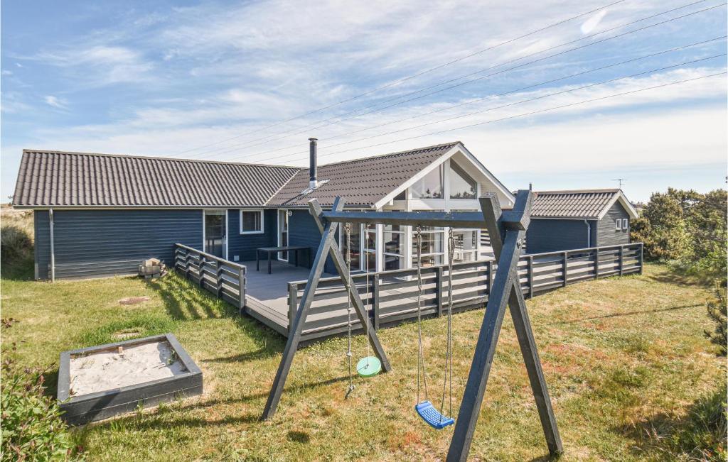 a house with a swing in the yard at Stunning Home In Hvide Sande With House A Panoramic View in Hvide Sande