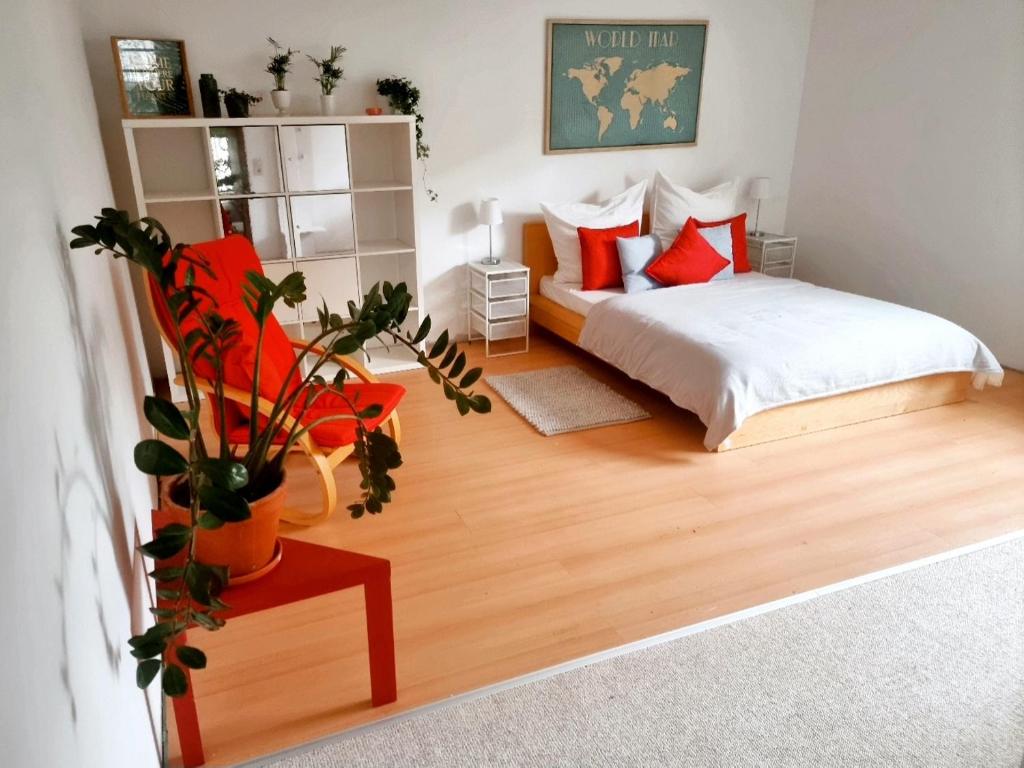 a bedroom with a bed with red pillows and a plant at Banaba in Wiesbaden