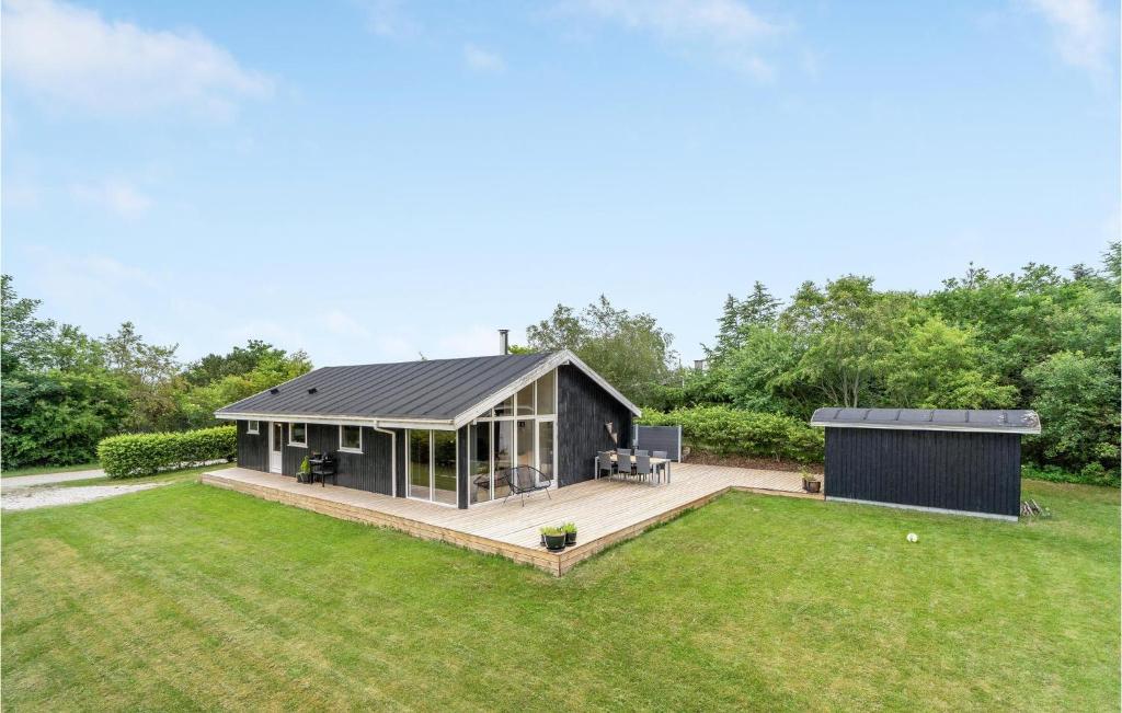 a house with a deck in a yard at 3 Bedroom Awesome Home In Fars in Hvalpsund