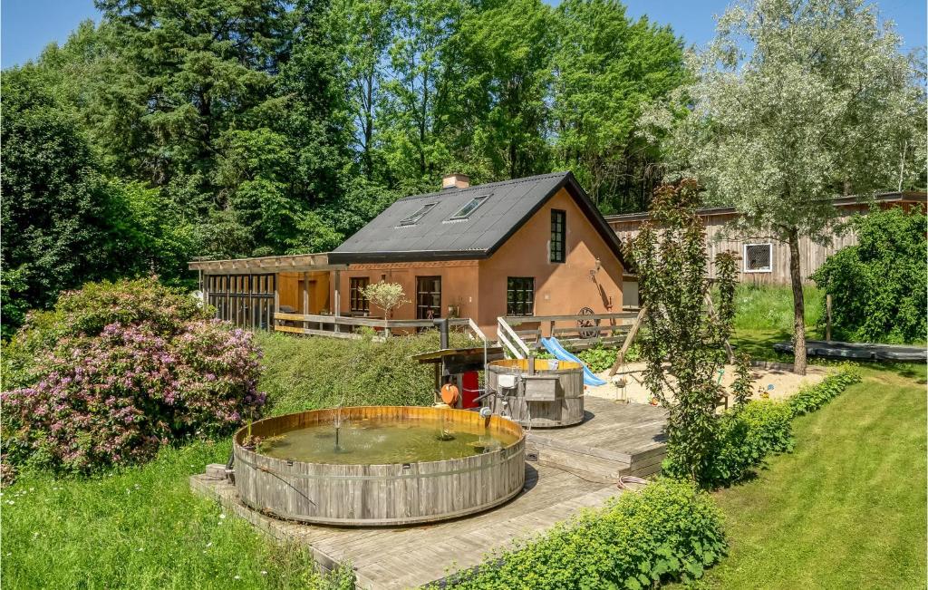 una pequeña casa con un patio con un estanque en 3 Bedroom Nice Home In Videbk, en Videbæk