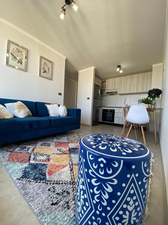a living room with a blue couch and a table at Marina Costa in Coquimbo