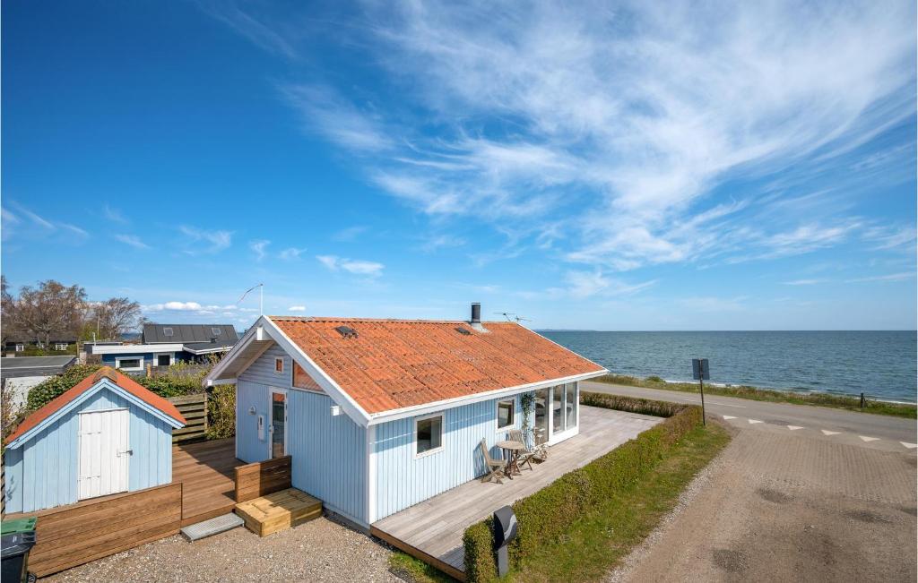 a white house with an orange roof next to the ocean at Amazing Home In Malling With Wifi in Ajstrup