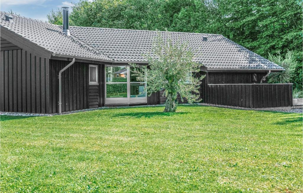 a house with a yard with a tree in it at Beautiful Home In Sydals With 4 Bedrooms, Sauna And Wifi in Skovby