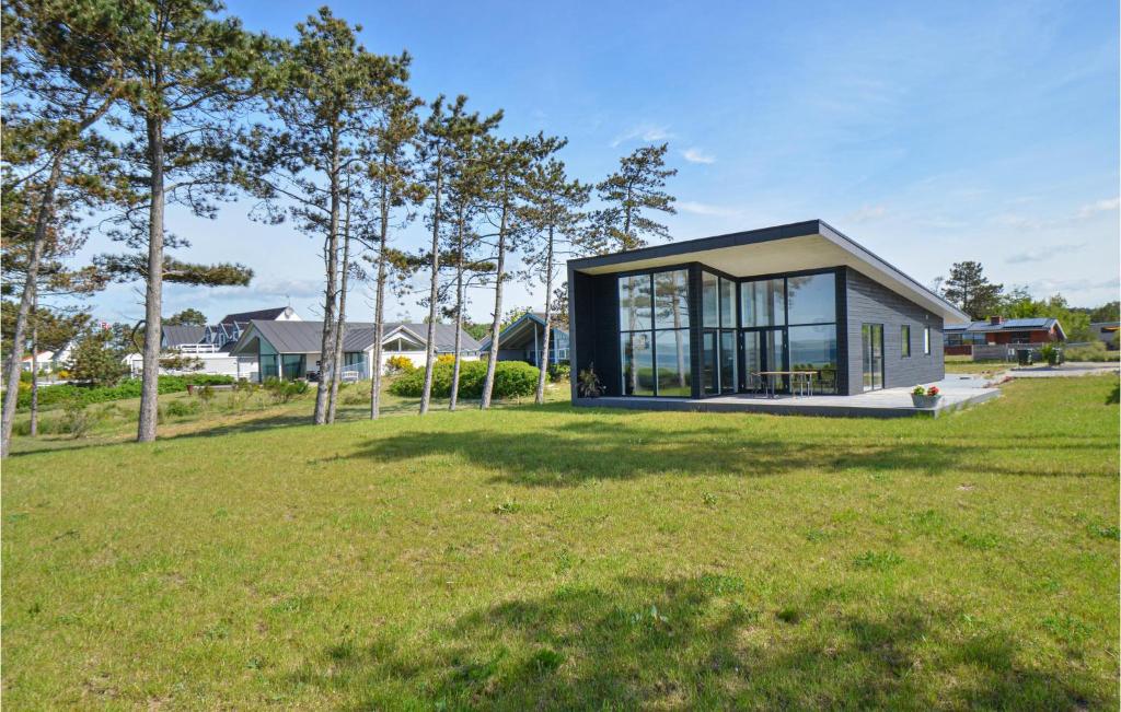 a small house with glass windows on a field at Gorgeous Home In Ebeltoft With Wifi in Ebeltoft