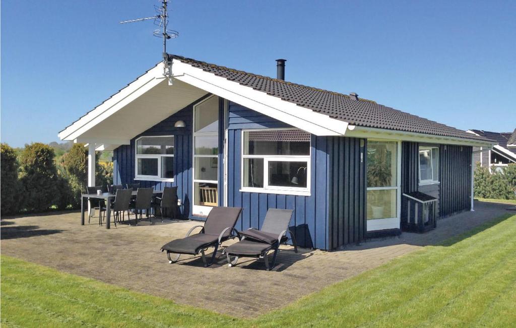 una casa azul con sillas y mesa en Nice Home In Sydals With Sauna, en Skovby