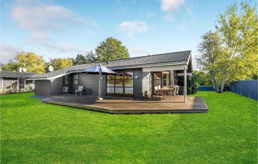 een klein huis met een terras en een paraplu bij Gorgeous Home In Slagelse With Kitchen in Slagelse