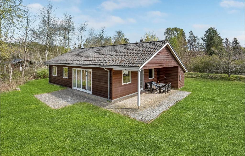 una pequeña cabaña en un campo de césped verde en Nice Home In Ebeltoft With Kitchen en Øksenmølle