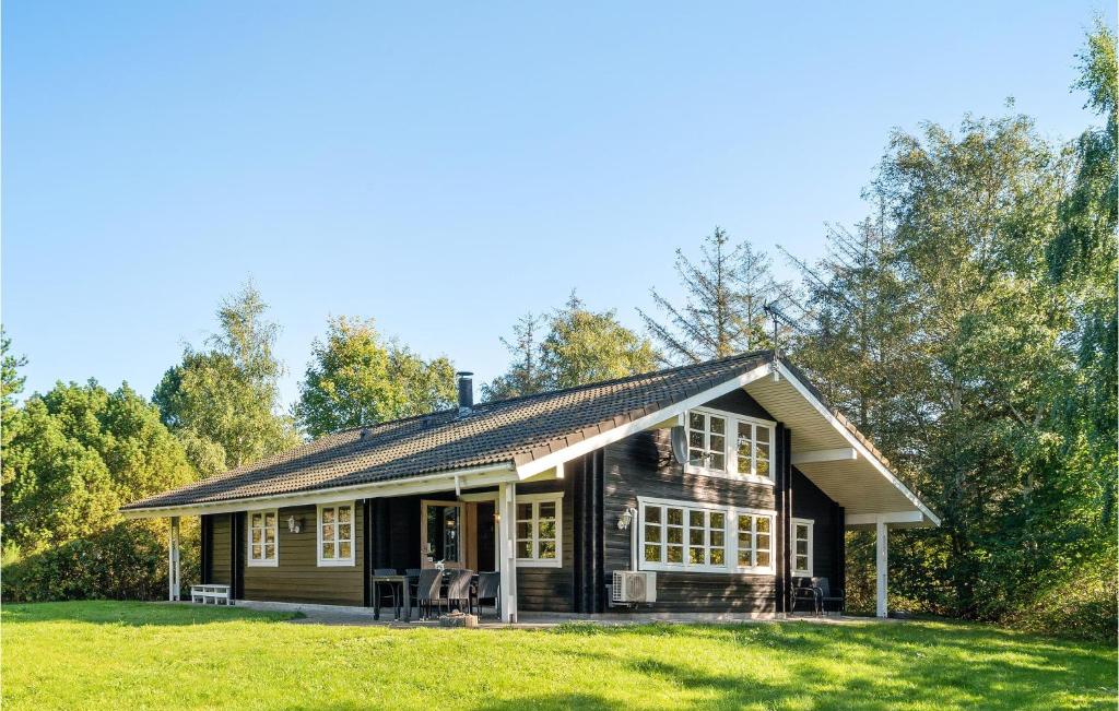 カロンボーにあるStunning Home In Kalundborg With 4 Bedrooms, Sauna And Wifiのポーチと芝生のあるログキャビン