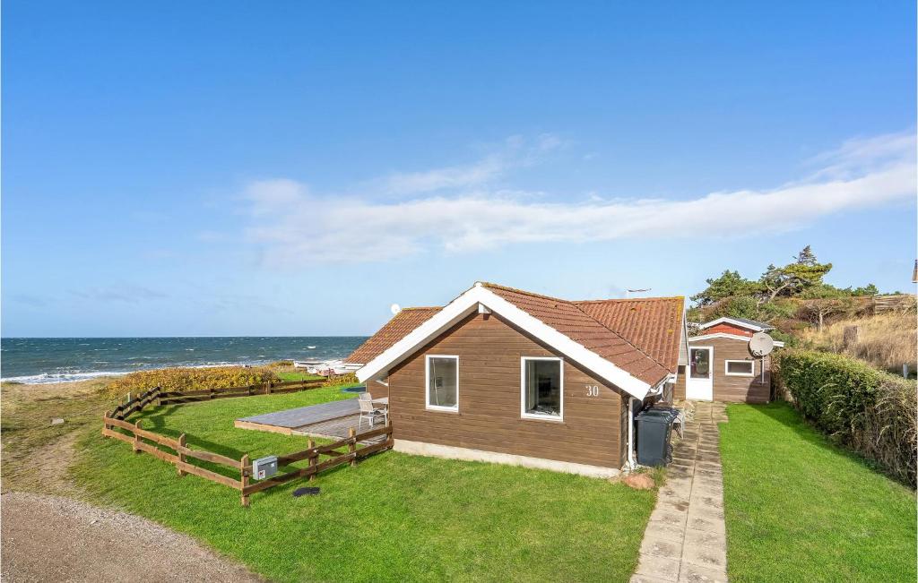 a house on the beach with the ocean in the background at Cozy Home In Slagelse With Kitchen in Slagelse