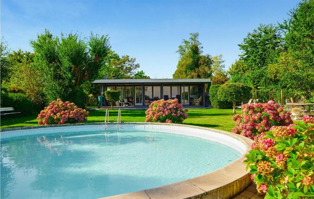 a large swimming pool in a garden with flowers at Beautiful Home In Odder With Outdoor Swimming Pool in Odder