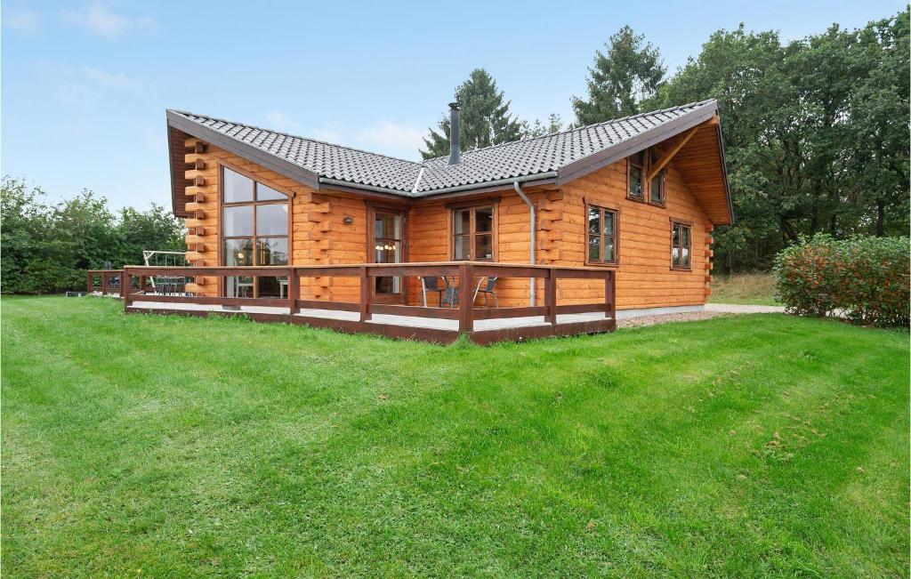 a log cabin with a large lawn in front of it at Awesome Home In Ejstrupholm With Sauna in Ejstrup