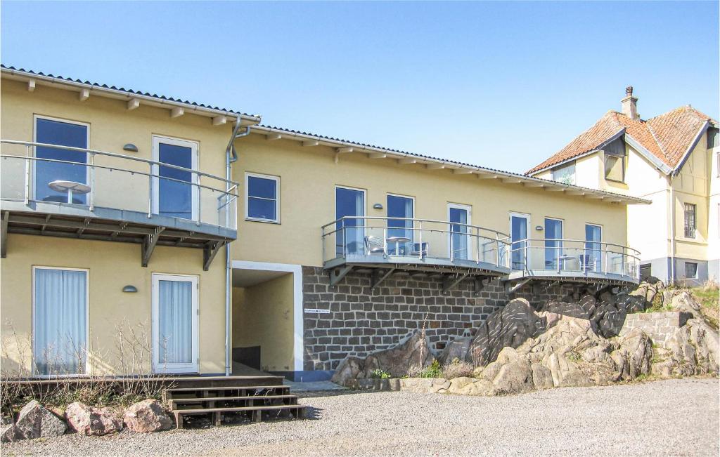 a yellow building with blue balconies on top of it at Gorgeous Apartment In Allinge With Wifi in Allinge