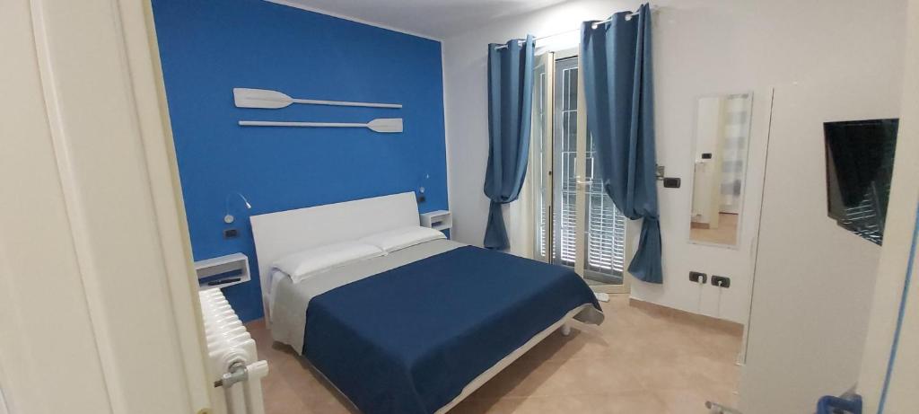 een blauwe slaapkamer met een bed en een blauwe muur bij Appartamento El Farol in Bordighera